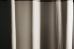 Custom-made curtains in beige and gold tones complementing a stylish bedroom