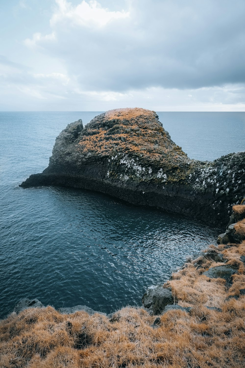 a rock outcropping in the middle of a body of water