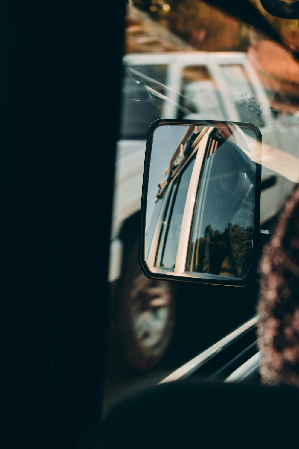 a side view mirror on a bus with a reflection of a bus