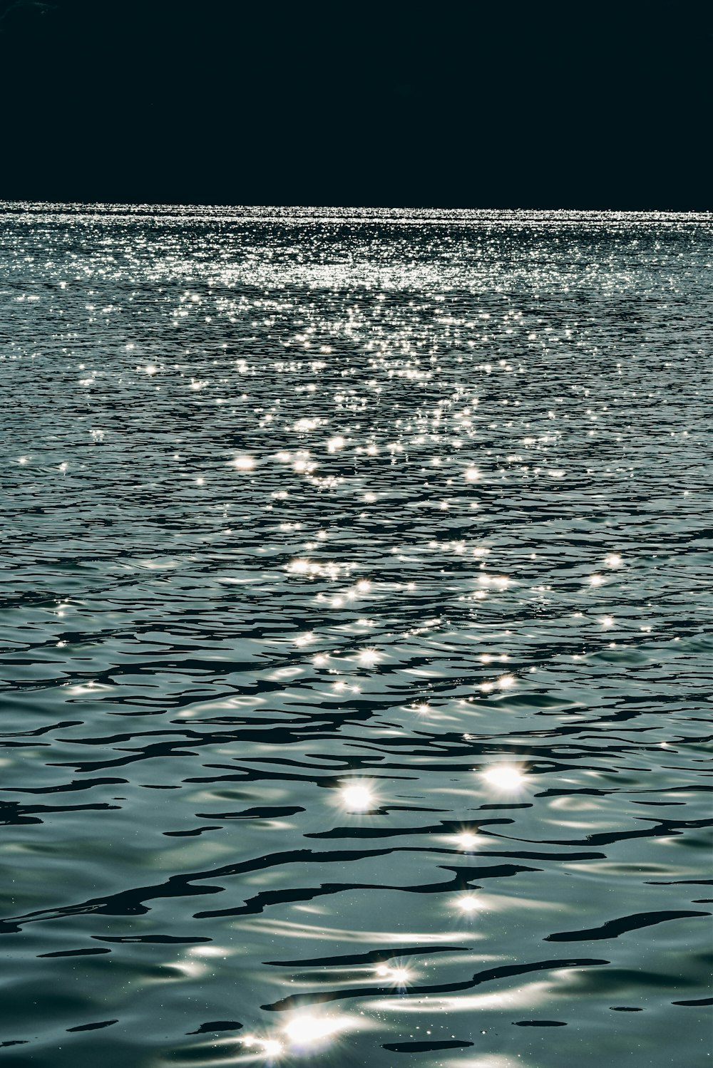 a large body of water with a boat in the distance