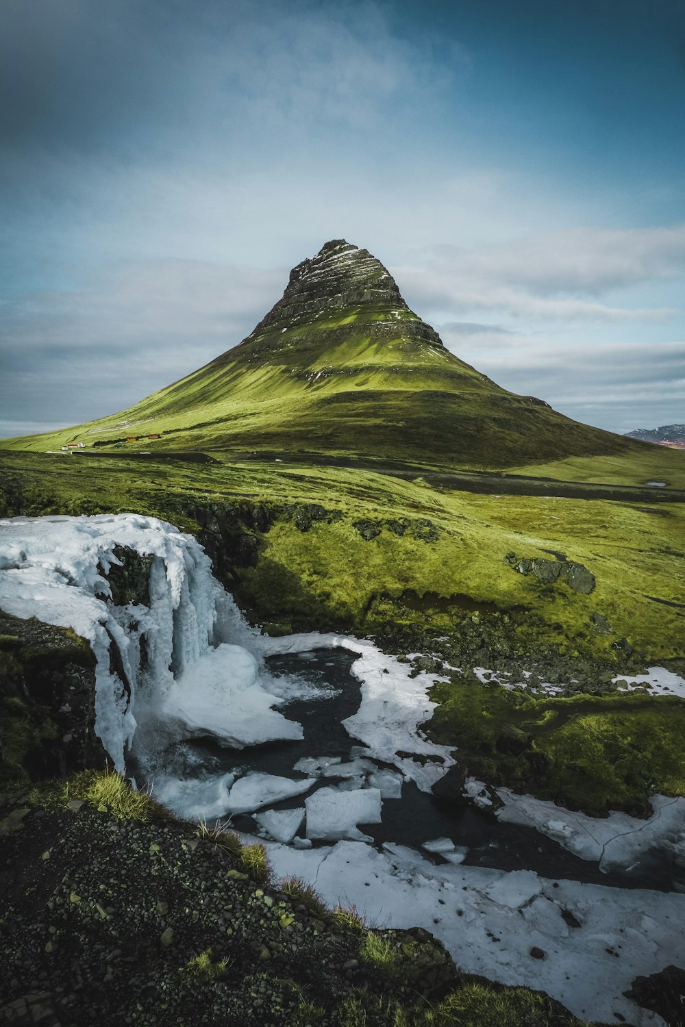 a mountain with a small waterfall in the middle of it