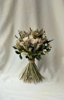 Hand tying a custom bouquet with natural greenery and delicate blooms.