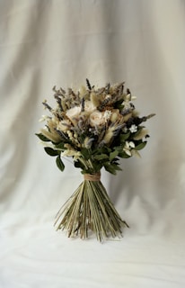 An eco-friendly bridal bouquet made of wildflowers and greenery, tied with a soft beige ribbon.