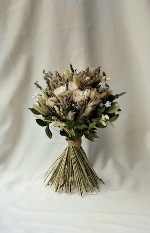 An eco-friendly bridal bouquet made of wildflowers and greenery, tied with a soft beige ribbon.