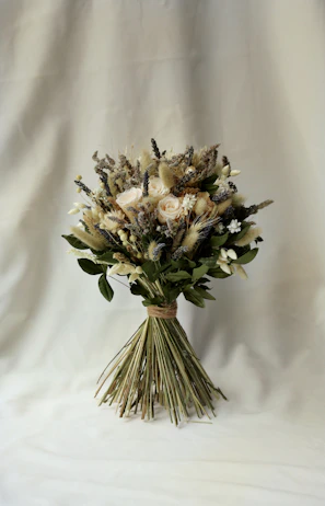 Hand tying a custom bouquet with natural greenery and delicate blooms.