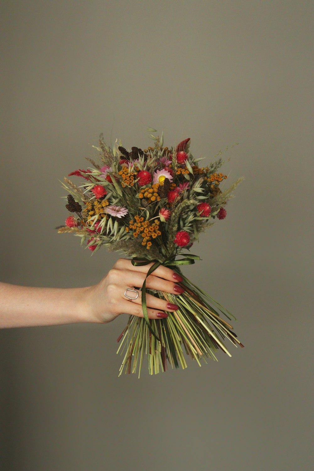 a person holding a bouquet of flowers in their hand