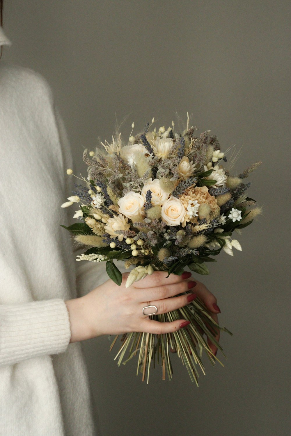 a woman holding a bouquet of flowers in her hands