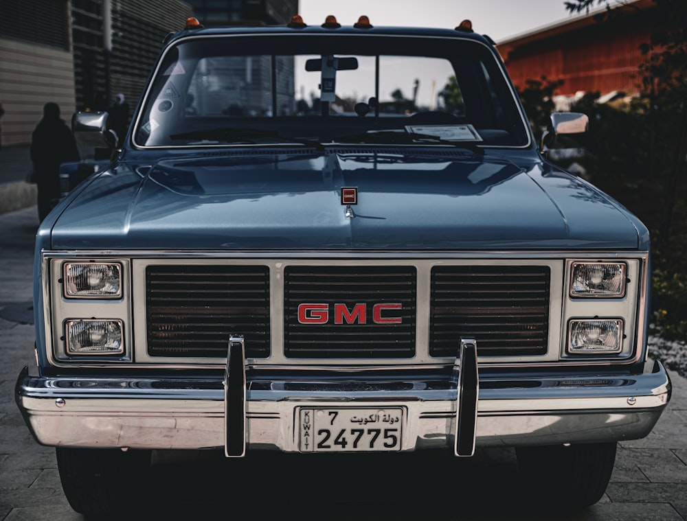 a blue gmc truck parked on the side of the road
