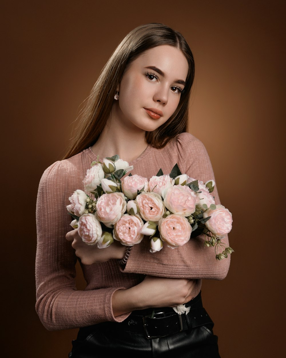 a woman holding a bunch of flowers in her hands