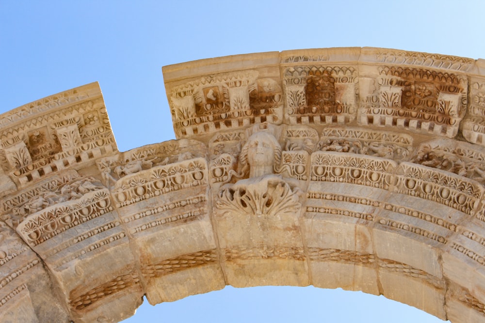 a close up of a stone arch with a sky background