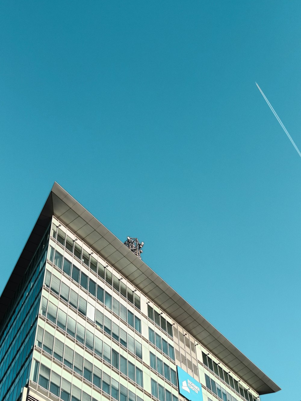 an airplane flying in the sky over a building