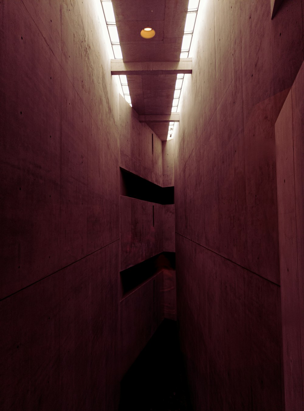a long narrow hallway with a light at the end