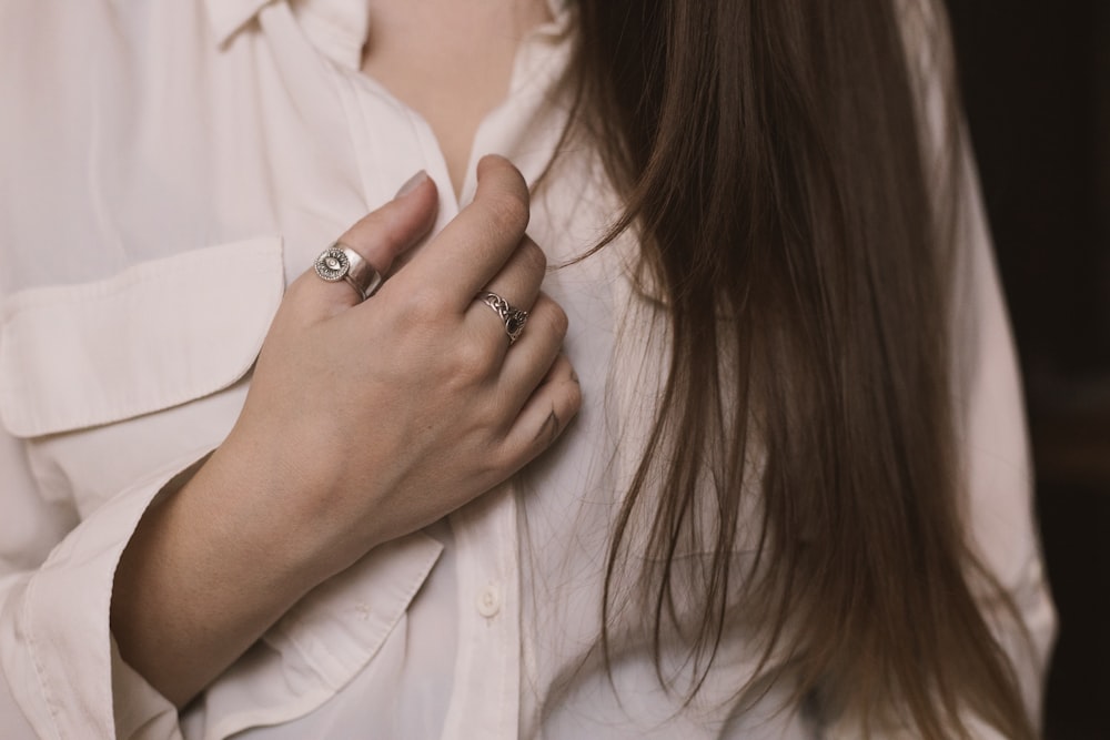 a woman wearing a white shirt and a silver ring