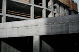 A close-up of reinforced concrete columns and beams under construction on a sunny day.