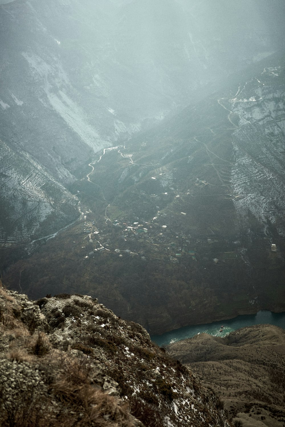 a person sitting on a mountain looking down at a valley