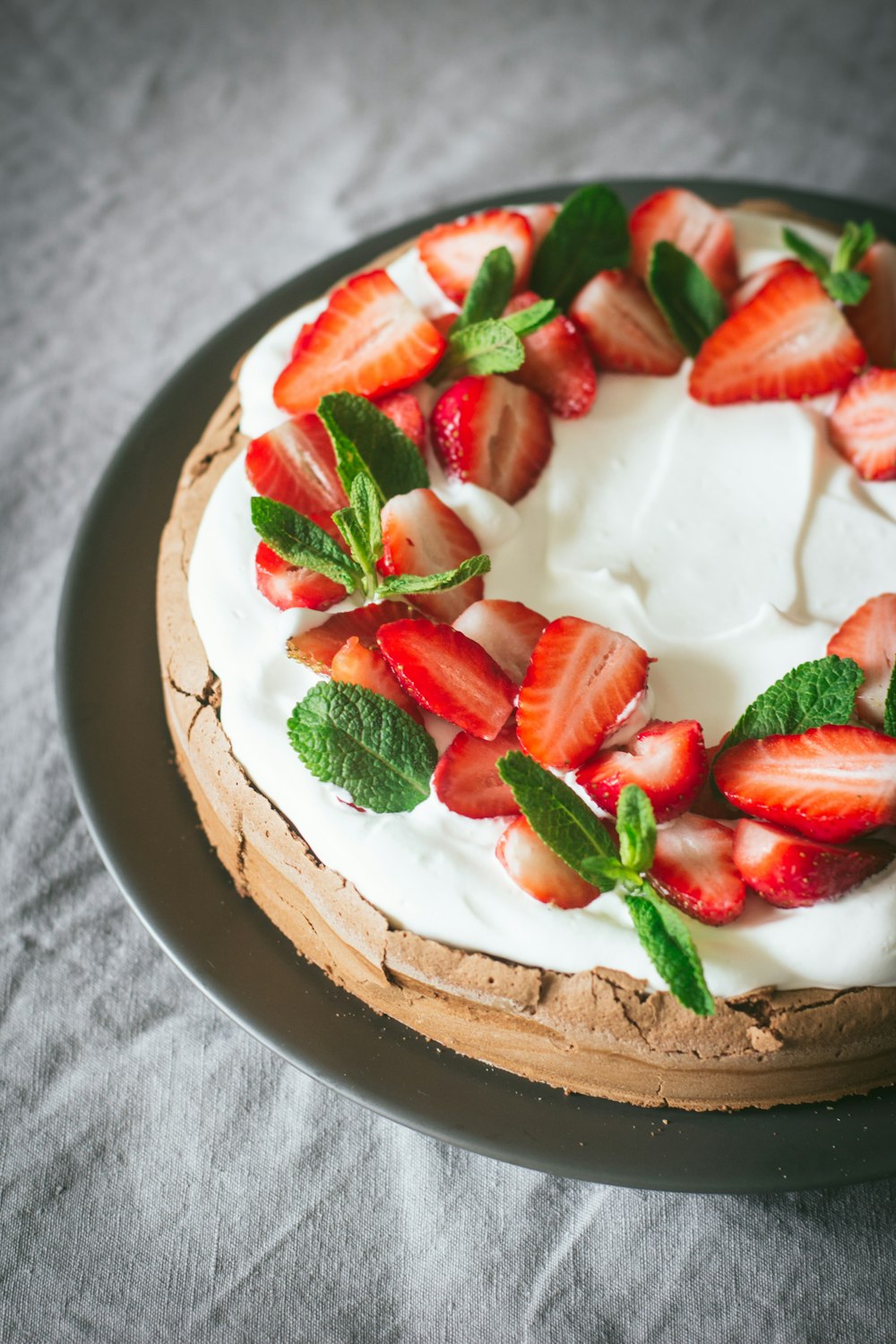 a cake with strawberries and mint on a plate