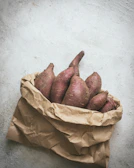 Artful arrangement of sweet potatoes and local herbs ready for cooking.