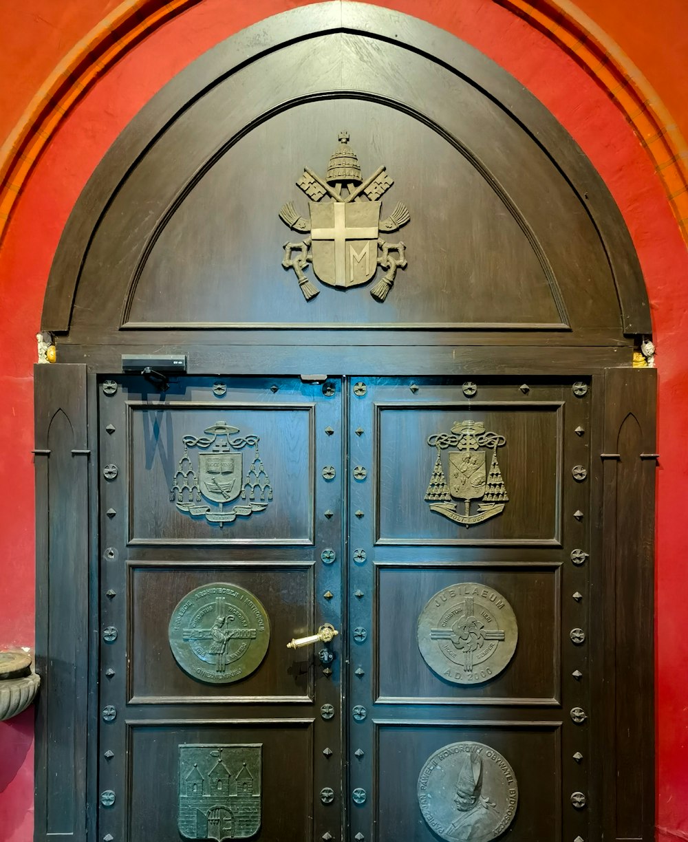 a large metal door in a red wall