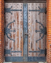 A sturdy steel door with the Fire Shield Metal Works logo etched on it, set against a workshop background.