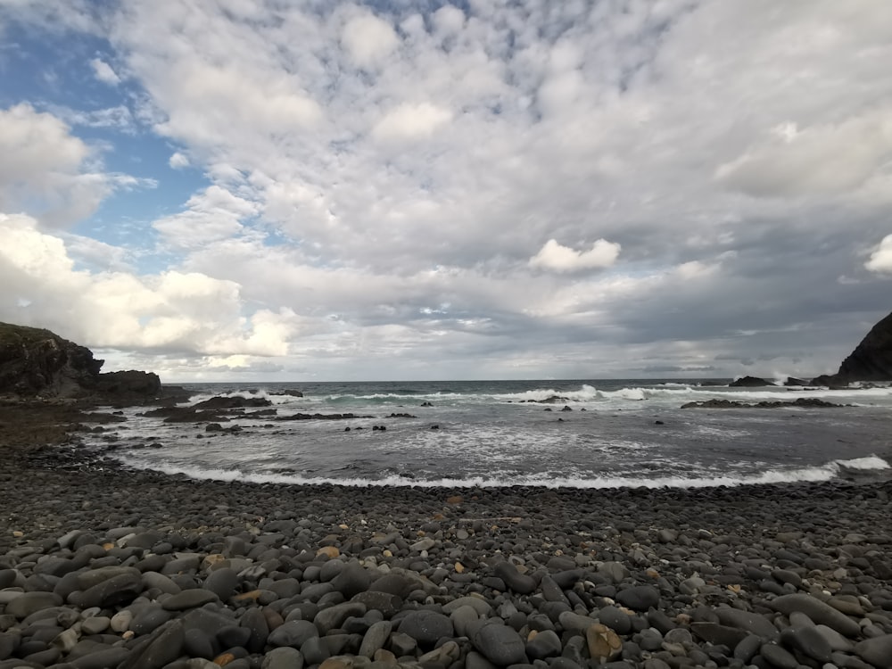 a rocky beach with waves coming in to shore