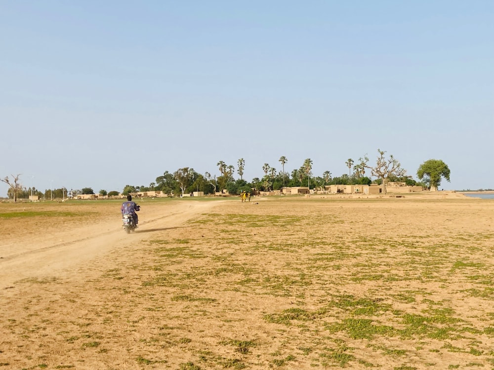 a man riding a motorcycle down a dirt road