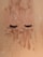 False eyelashes are laid on a sandy surface dusted with specks of brown and white powder.