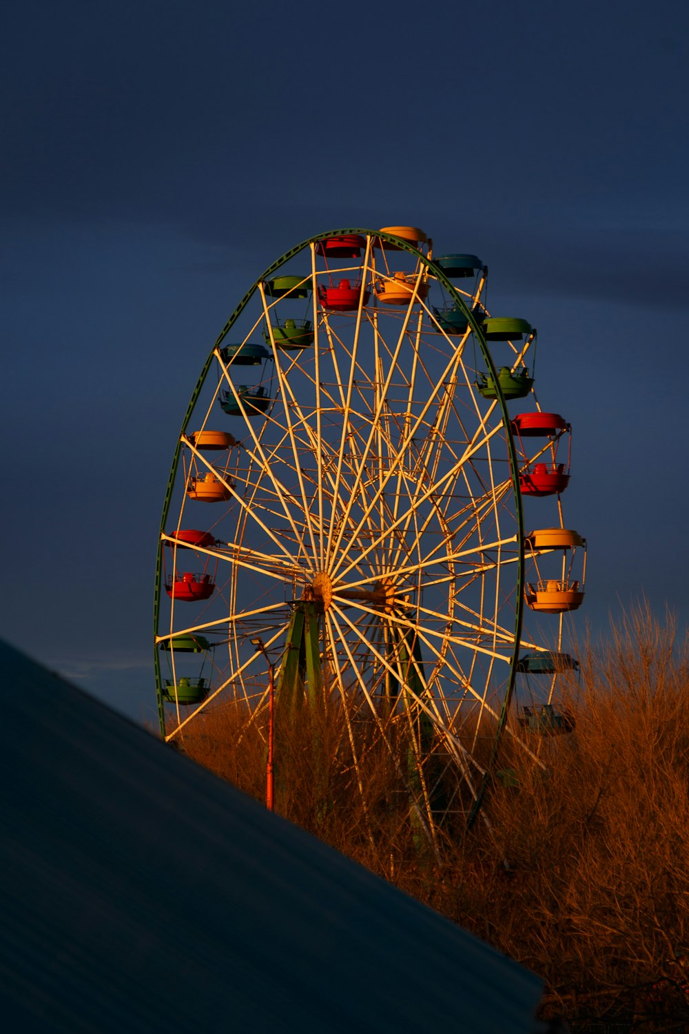 a ferris wheel sitting on top of a grass covered field