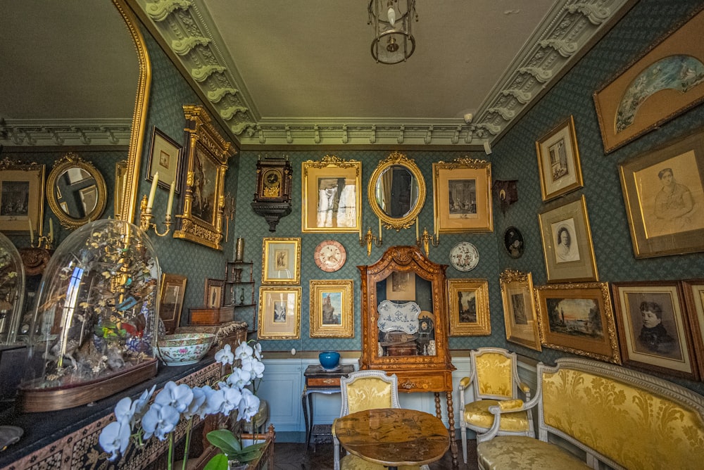 a room filled with lots of framed pictures and furniture