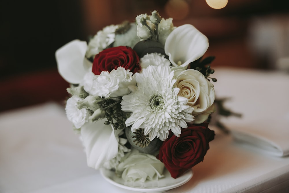 a bouquet of white and red flowers on a table