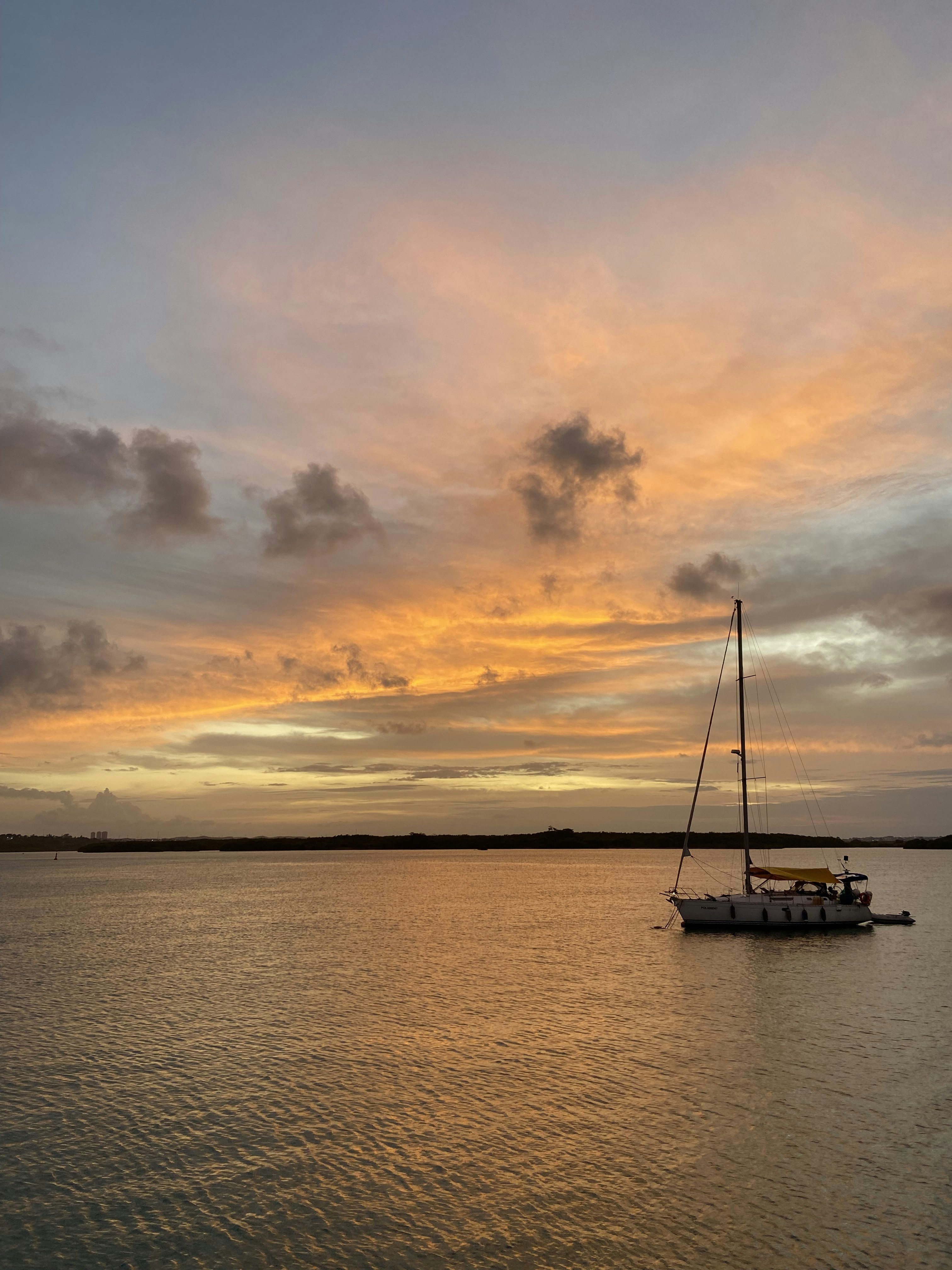 a sailboat in the water at sunset
