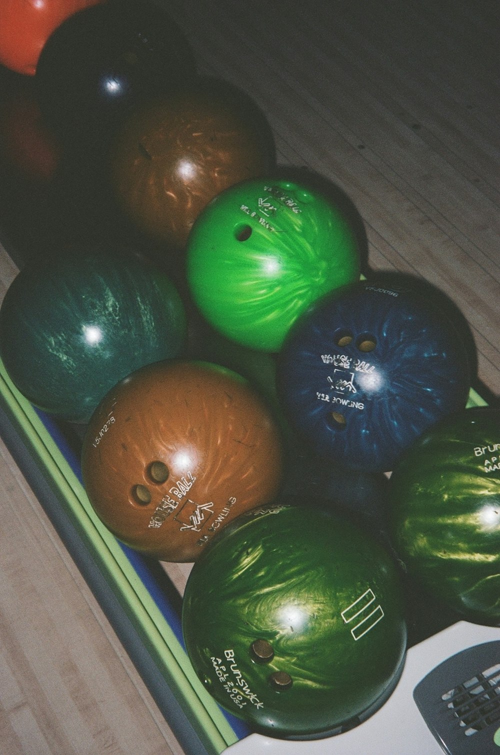 a group of bowling balls sitting on top of a wooden floor