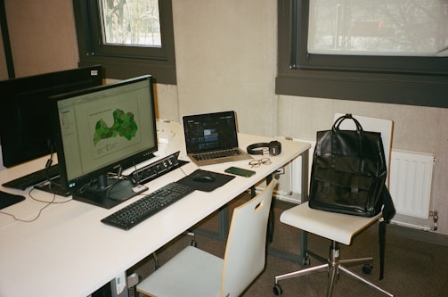 A modern office desk with a global map and communication devices.