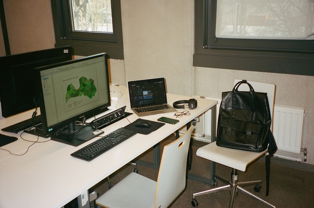 un escritorio blanco con una computadora portátil y una computadora