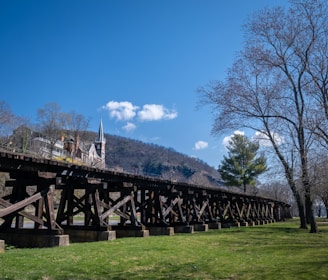 a large wooden bridge over a lush green field