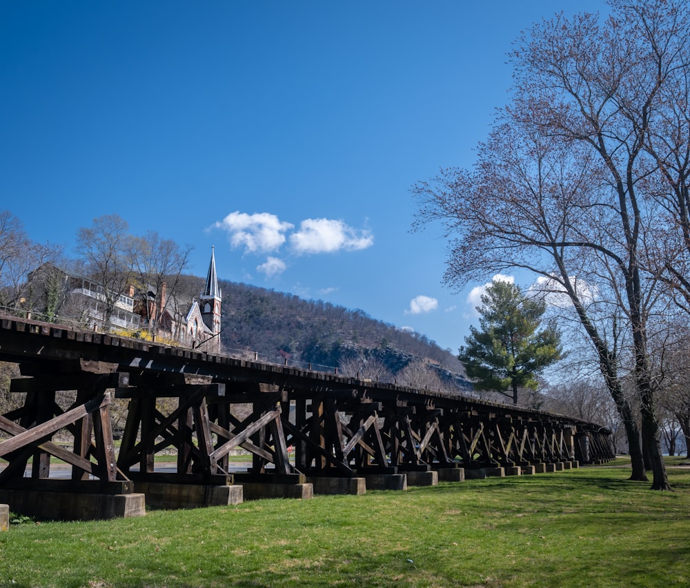 a large wooden bridge over a lush green field