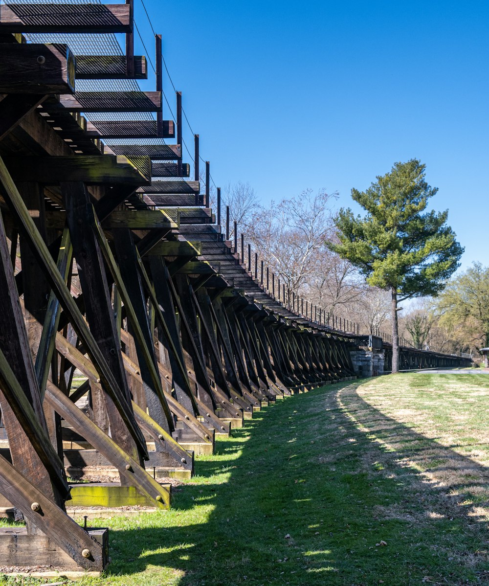 a long row of wooden benches sitting on top of a lush green field