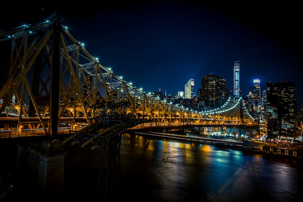 a large bridge spanning over a river with a city in the background