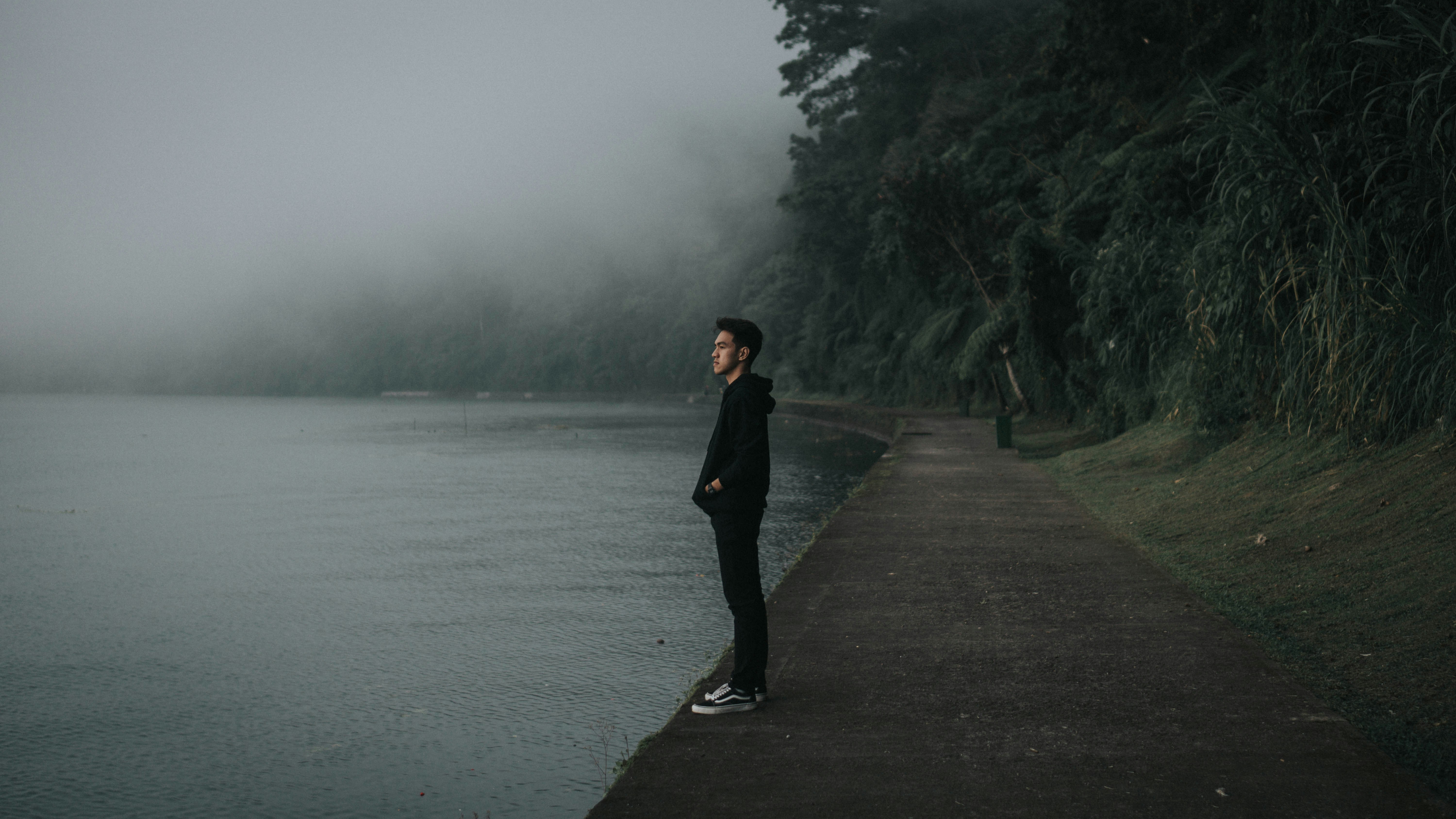 a person standing on a path next to a body of water
