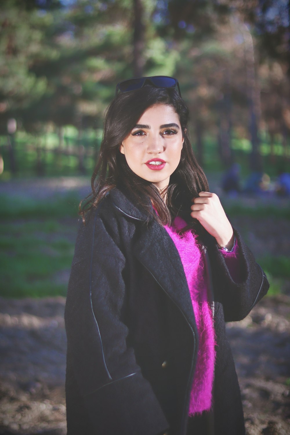 a woman in a black coat and pink sweater