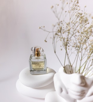 Elegant minimalist perfume bottle with golden accents on a clean white background