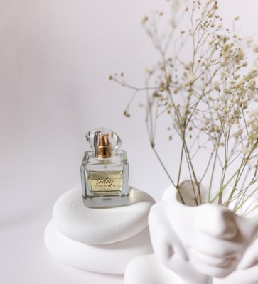 Elegant perfume bottle with golden accents on a minimalist white marble surface