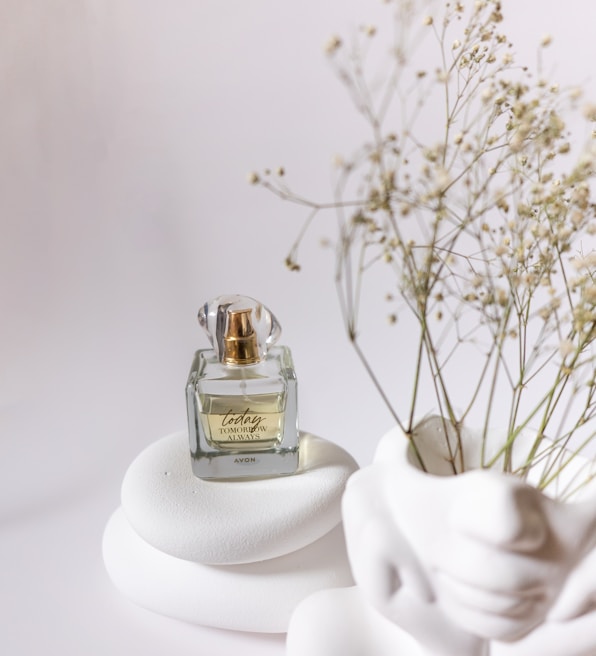 Elegant Ard Al Zaafaran perfume bottle with metallic gold accents displayed on a minimalist white marble surface.