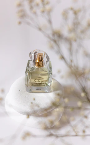 Close-up of a delicate fragrance spray releasing mist in soft golden light