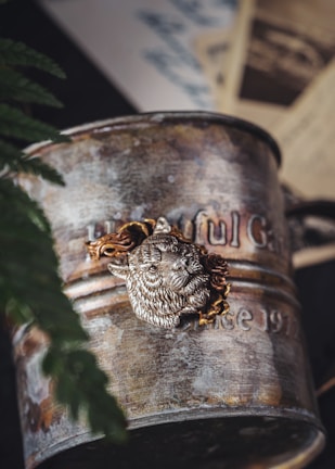 Close-up of an antique pewter tankard with intricate engravings.