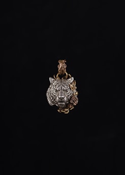 Pendant featuring a wolf’s head carved in dark metal with intricate detail.