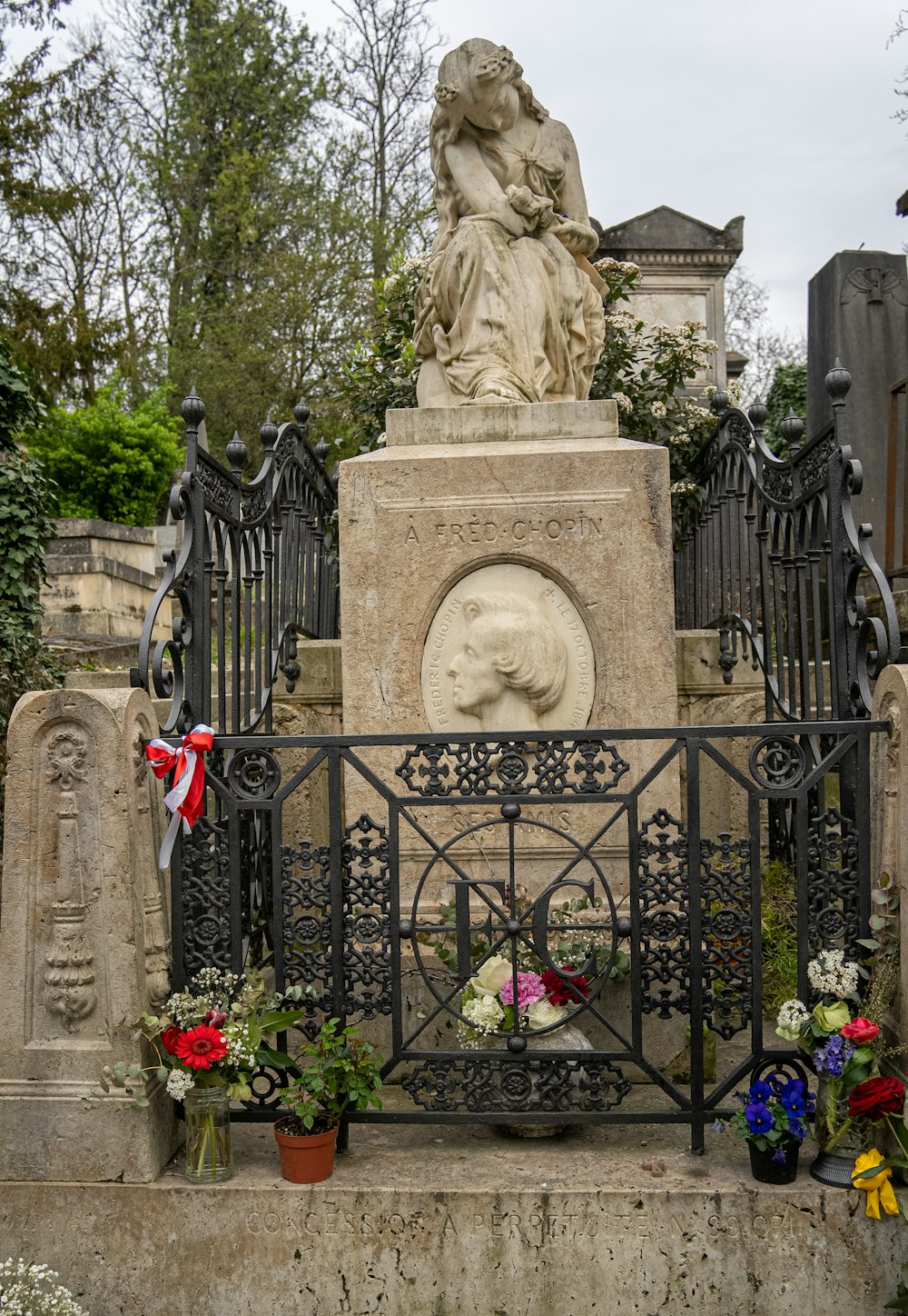 une statue d’une femme assise au sommet d’une tombe