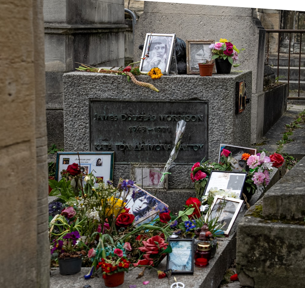 a grave with flowers and pictures on it