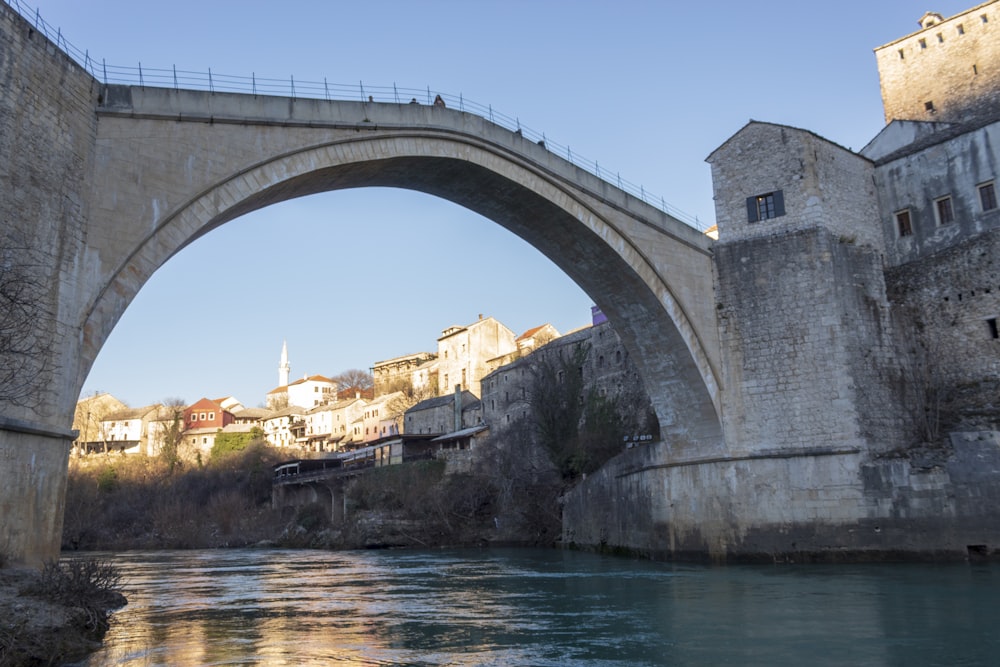 a bridge over a body of water with buildings in the background