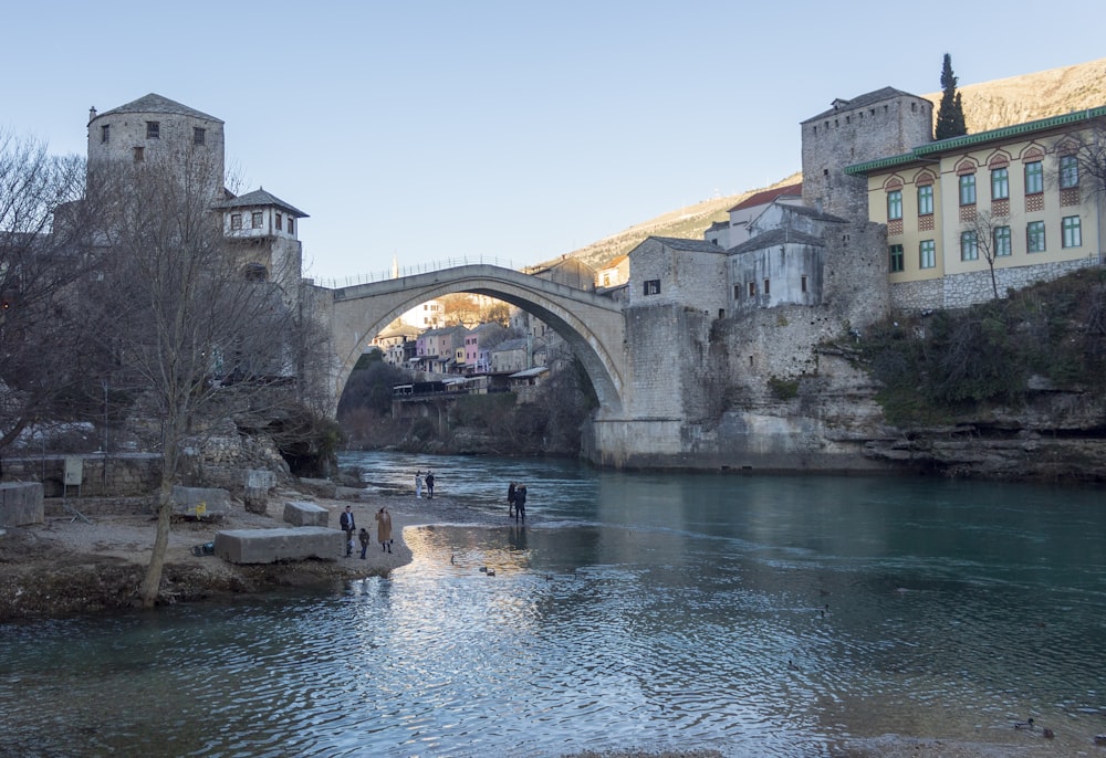 a bridge over a river next to a tall building