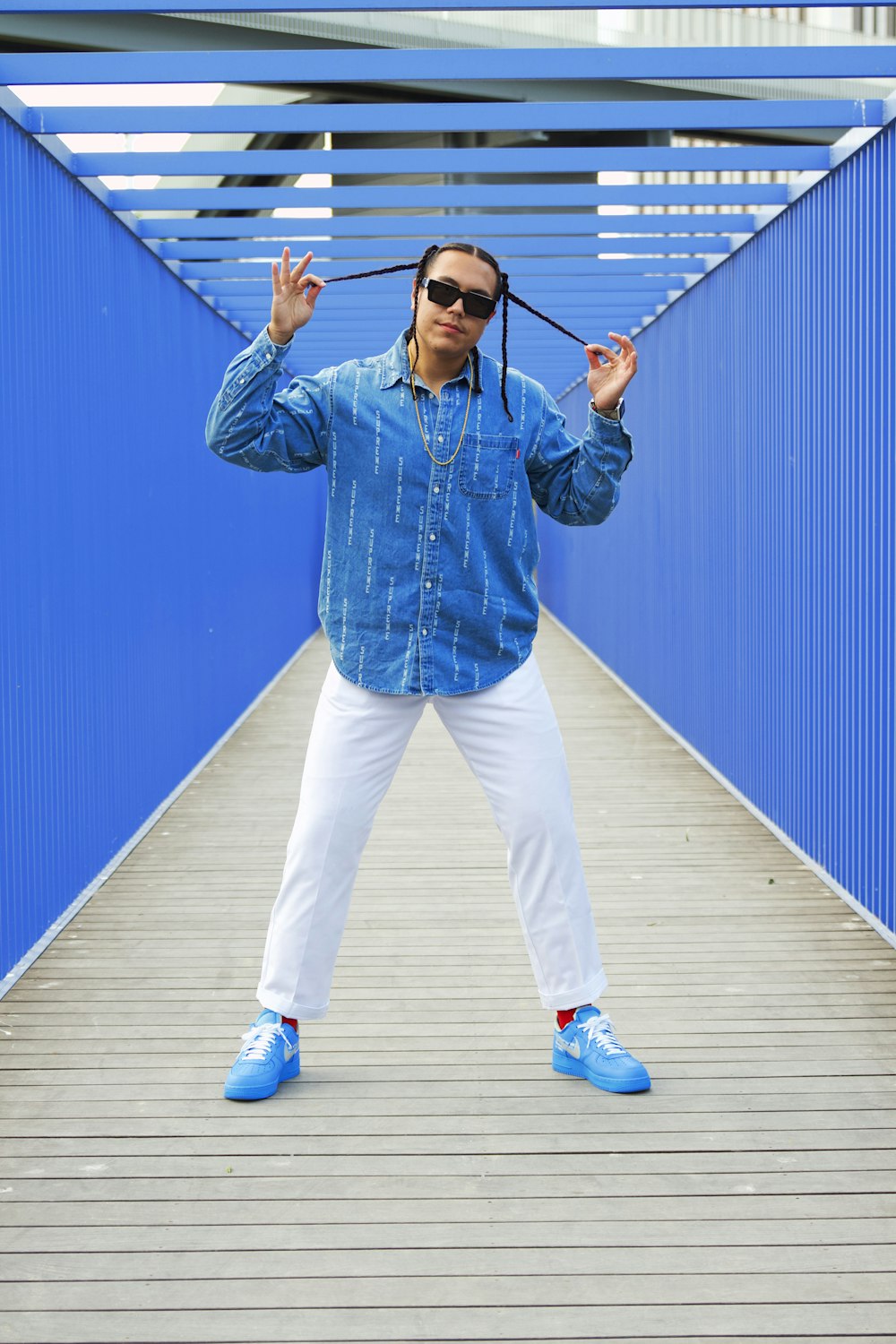 a man standing on a bridge with a pair of sunglasses on his head